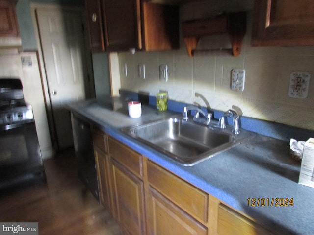 kitchen with decorative backsplash, stove, sink, and exhaust hood