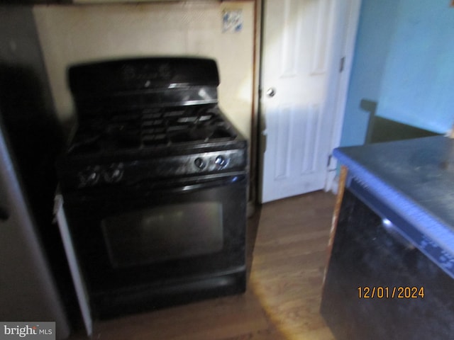 kitchen featuring black gas range and dark hardwood / wood-style floors