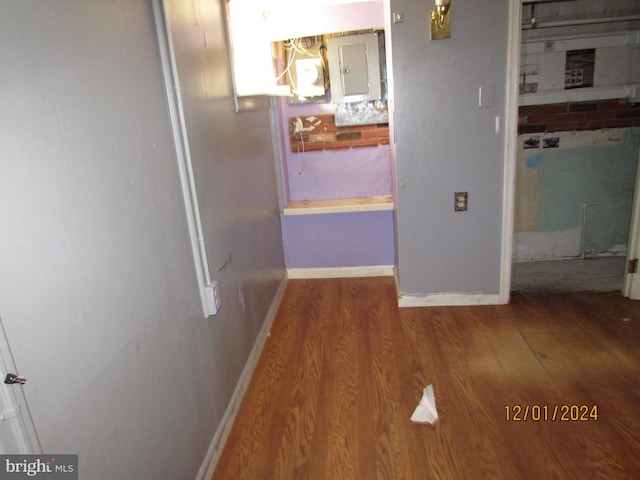 corridor with hardwood / wood-style floors and electric panel