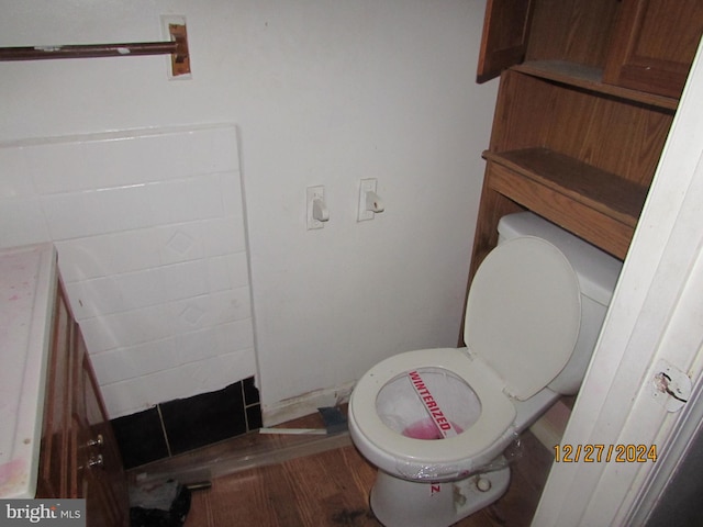 bathroom featuring hardwood / wood-style flooring and toilet