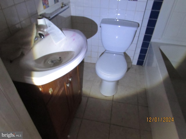 bathroom featuring backsplash, tile patterned flooring, toilet, a tub to relax in, and tile walls