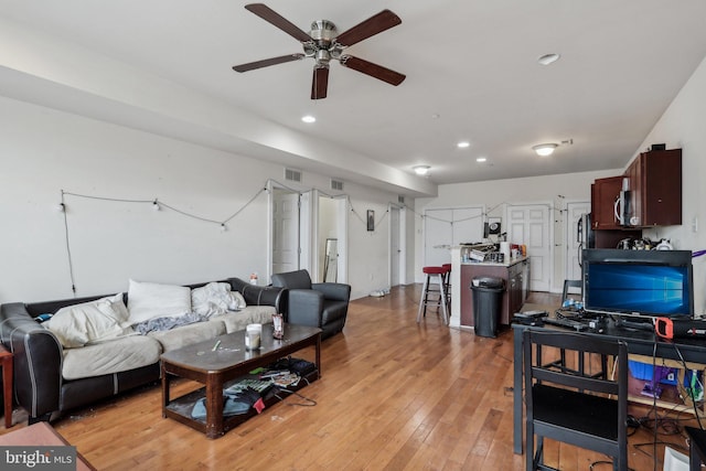 living room with ceiling fan and light wood-type flooring