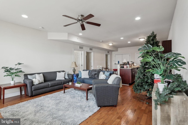 living room featuring wood-type flooring and ceiling fan