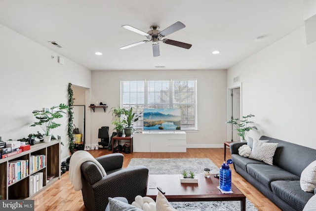 living room featuring light hardwood / wood-style floors and ceiling fan