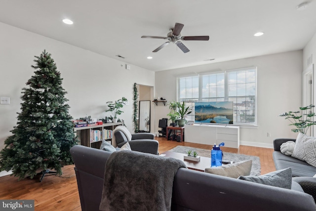 living room with ceiling fan and light hardwood / wood-style flooring