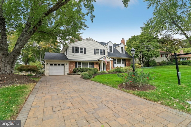 view of front of home with a garage and a front lawn