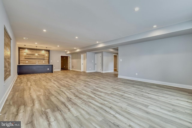 unfurnished living room with baseboards, light wood-style floors, and recessed lighting