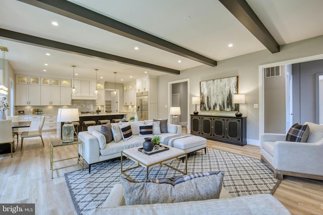 living room featuring light wood-type flooring, visible vents, beam ceiling, and recessed lighting