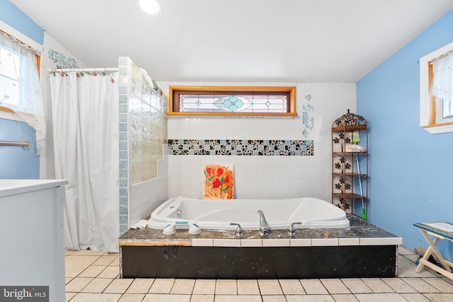 bathroom with tiled bath and tile patterned flooring