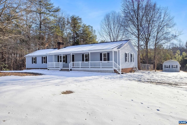 view of front of home with a porch and a storage unit