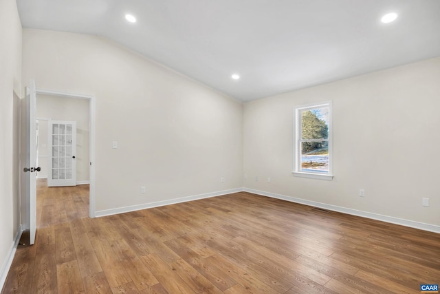 unfurnished room with lofted ceiling and hardwood / wood-style floors