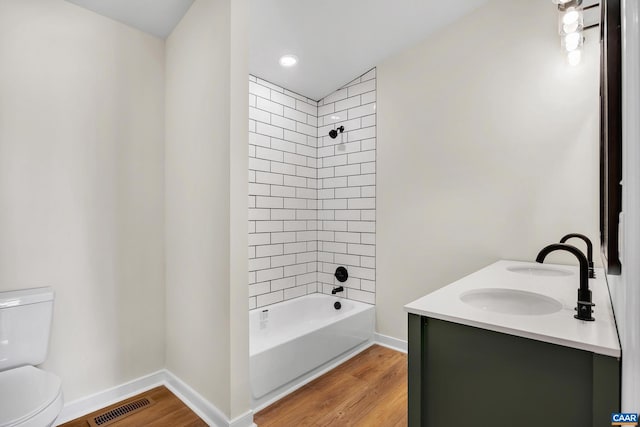 full bathroom featuring tiled shower / bath, wood-type flooring, toilet, and vanity