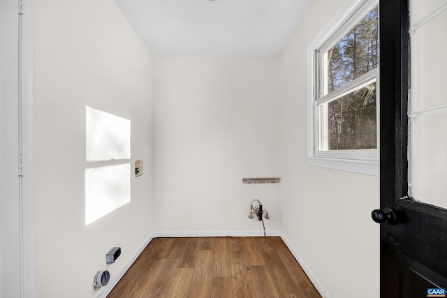 clothes washing area with hardwood / wood-style flooring and hookup for a washing machine