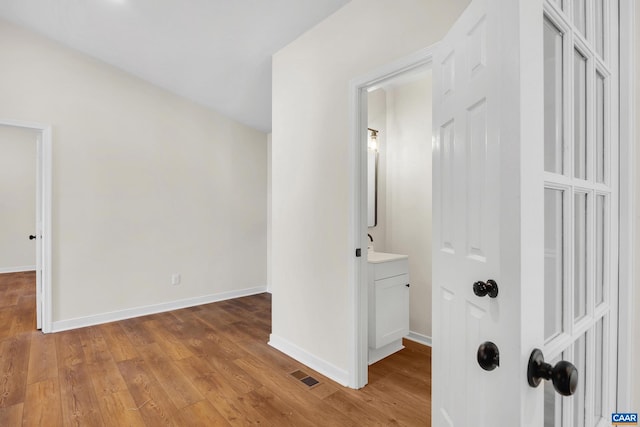 hallway with light hardwood / wood-style floors