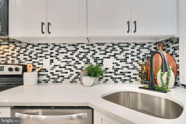 kitchen featuring dishwasher, white cabinetry, sink, and tasteful backsplash