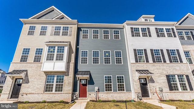 townhome / multi-family property featuring a front yard