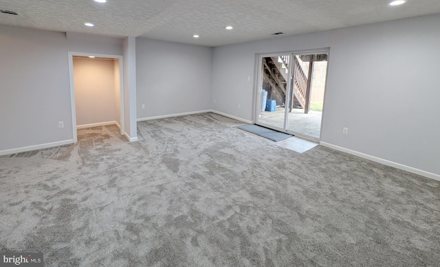 unfurnished room with a textured ceiling and light carpet