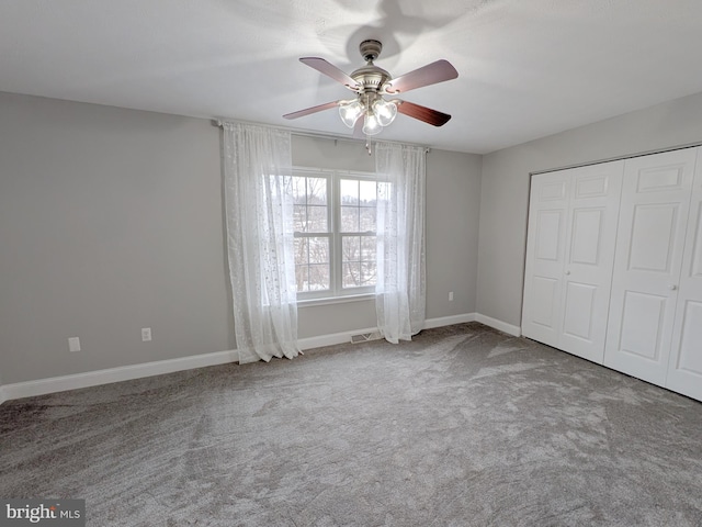 unfurnished bedroom with ceiling fan, carpet, and a closet