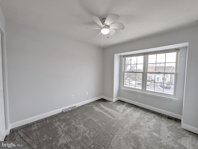 carpeted spare room with ceiling fan