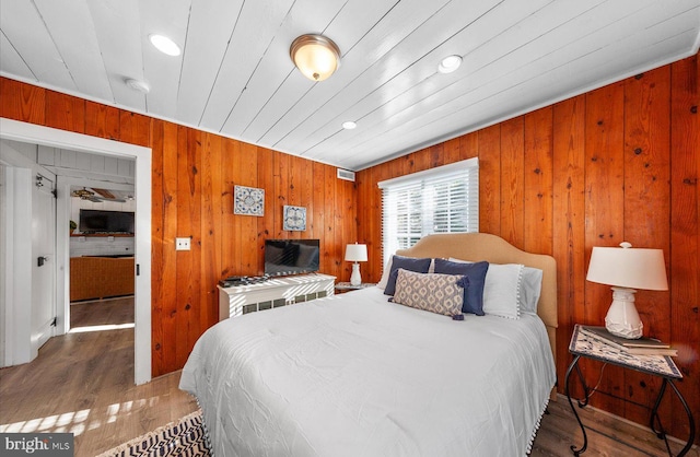 bedroom featuring wooden ceiling, wood-type flooring, and wood walls