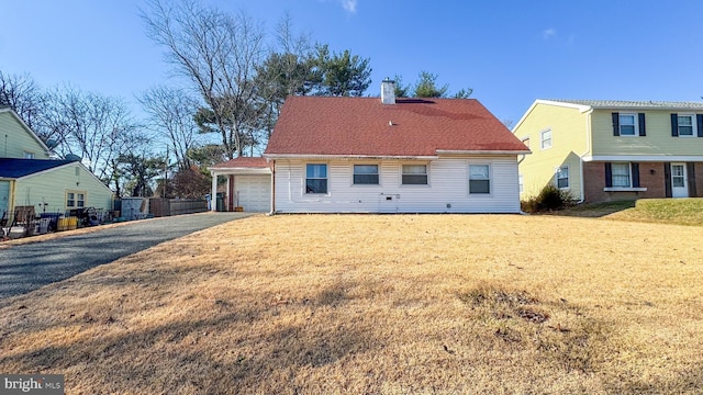 back of property featuring a lawn and a garage