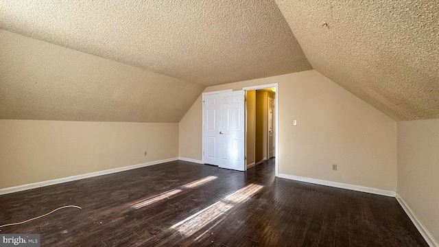 bonus room featuring vaulted ceiling, dark hardwood / wood-style floors, and a textured ceiling