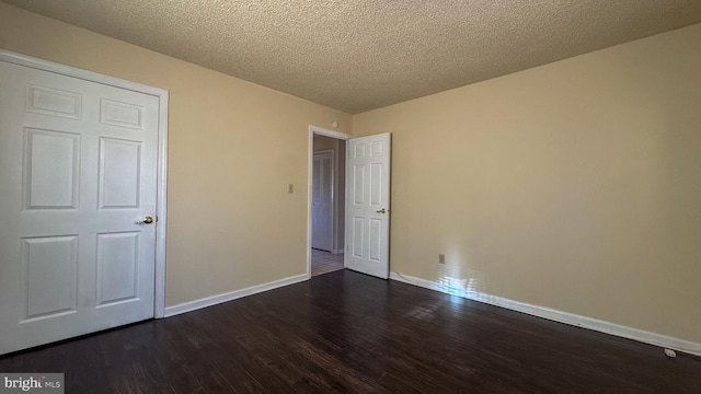 unfurnished bedroom featuring dark wood-type flooring and a textured ceiling