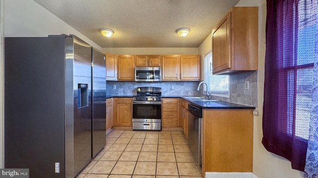 kitchen with sink, light tile patterned floors, stainless steel appliances, and tasteful backsplash