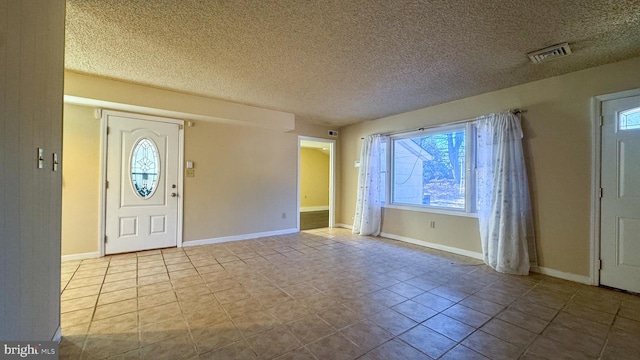 tiled foyer entrance with a textured ceiling