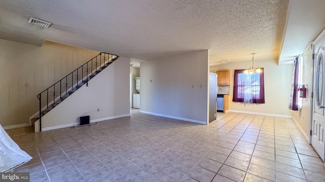 unfurnished living room with tile patterned flooring, a textured ceiling, and a notable chandelier