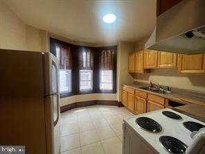 kitchen with white appliances, extractor fan, and sink