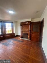 unfurnished living room with dark wood-type flooring