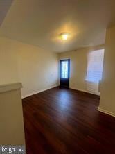 empty room with dark hardwood / wood-style flooring