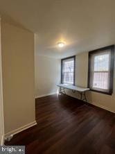 unfurnished room featuring dark wood-type flooring