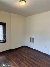 spare room featuring dark hardwood / wood-style floors