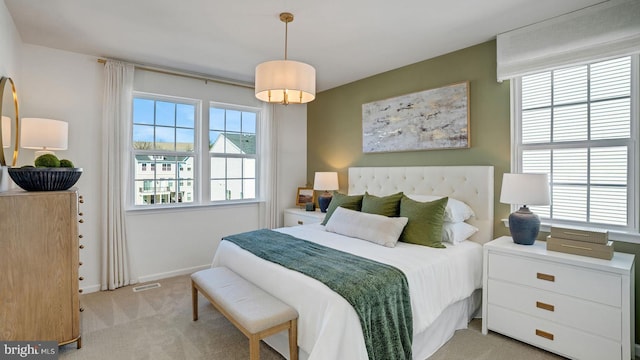 carpeted bedroom featuring multiple windows