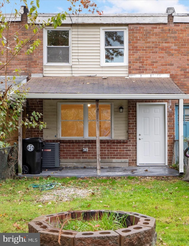 back of house with cooling unit and a lawn