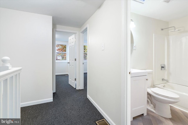 interior space featuring vanity, toilet, and shower / tub combination