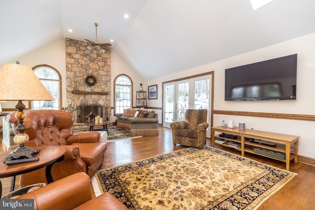 living room featuring lofted ceiling, hardwood / wood-style floors, and a fireplace