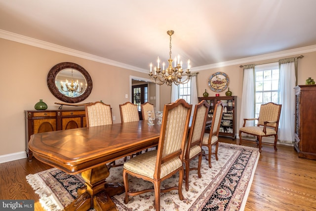 dining room with hardwood / wood-style flooring, ornamental molding, and a chandelier