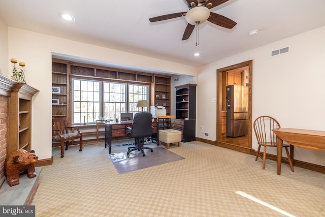 carpeted home office featuring built in features and ceiling fan