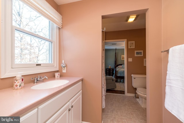 bathroom with tile patterned flooring, vanity, and toilet