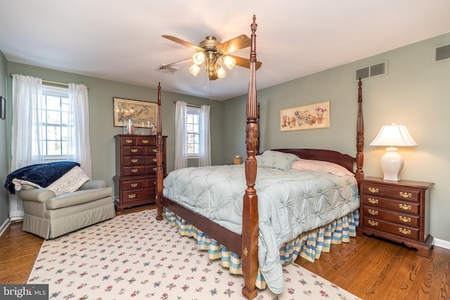 bedroom featuring multiple windows, hardwood / wood-style flooring, and ceiling fan