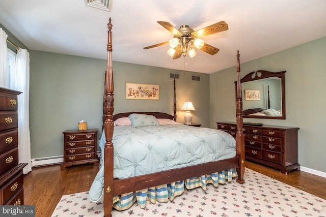 bedroom featuring a baseboard radiator, dark hardwood / wood-style floors, and ceiling fan