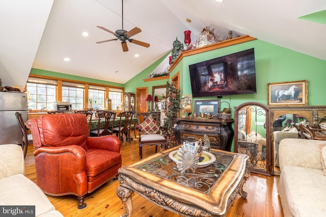 living room with vaulted ceiling, ceiling fan, and light hardwood / wood-style floors