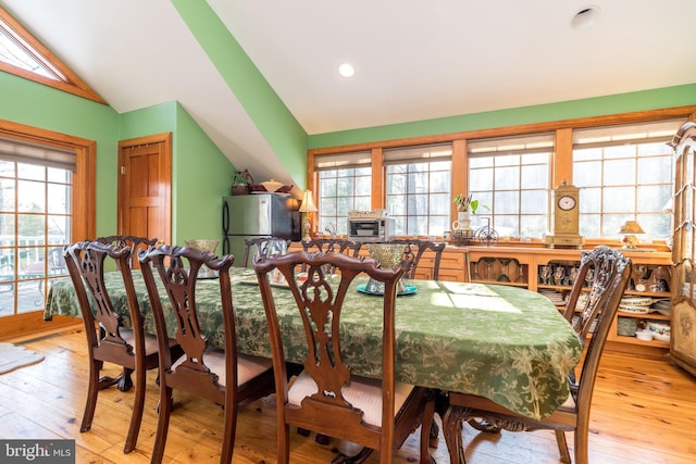 dining area with lofted ceiling and light hardwood / wood-style floors