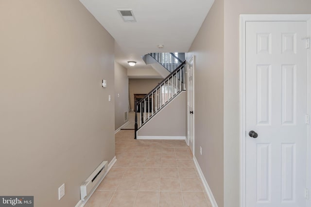 hallway with baseboard heating and light tile patterned floors