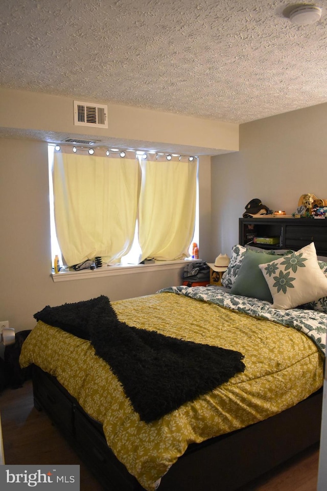 bedroom featuring hardwood / wood-style floors and a textured ceiling