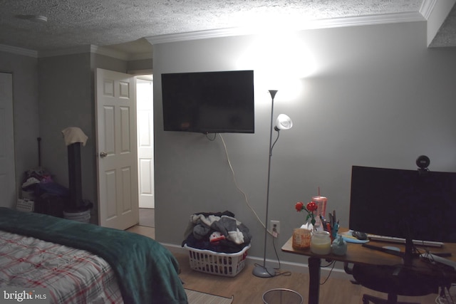 bedroom with wood-type flooring, a textured ceiling, and ornamental molding