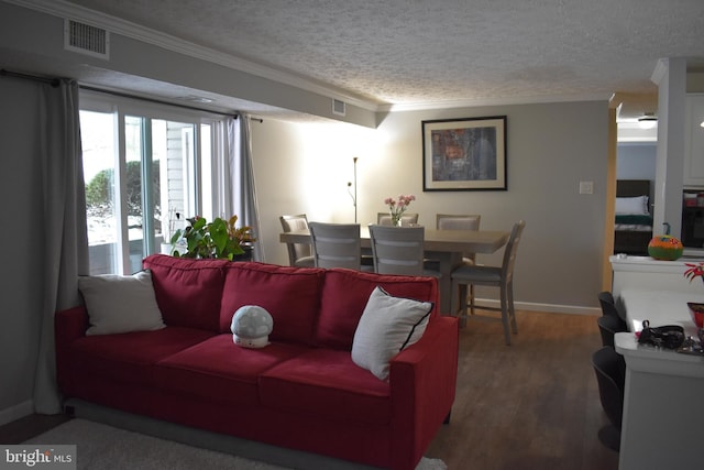 living room with crown molding, wood-type flooring, and a textured ceiling